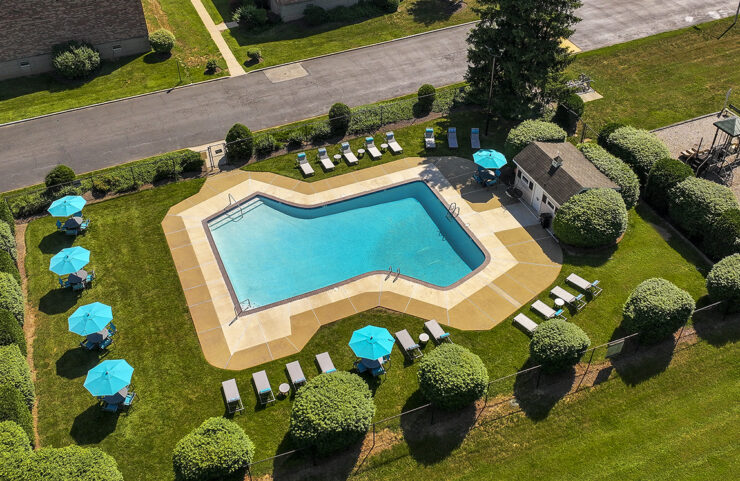 aerial view of outdoor pool with apartment in background