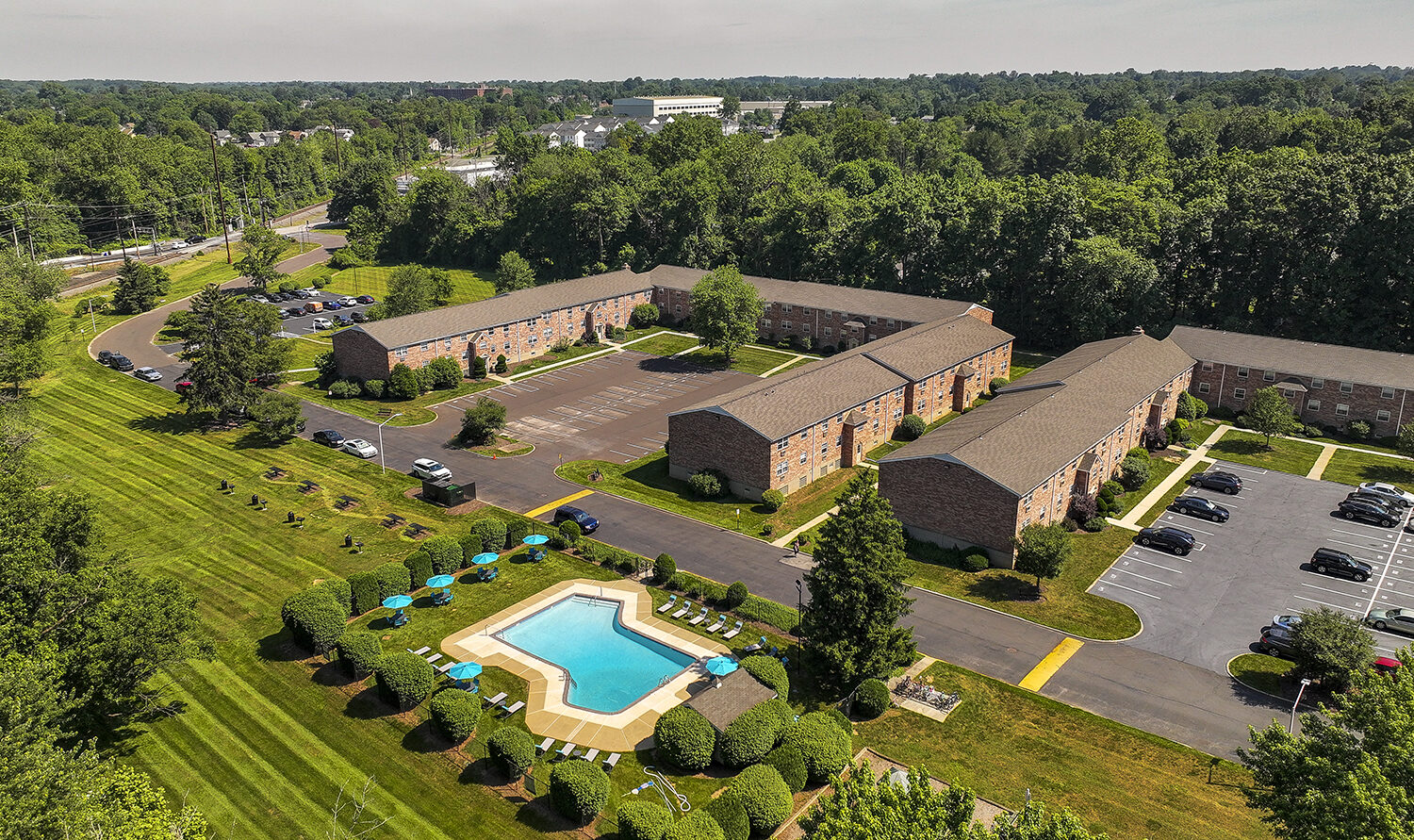 aerial view of outdoor pool with apartment in background