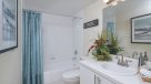 bathroom with white vanity adn tiled tub 