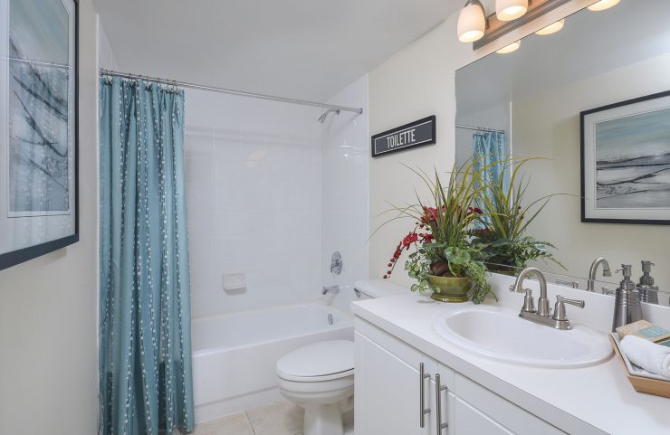 bathroom with white vanity adn tiled tub 