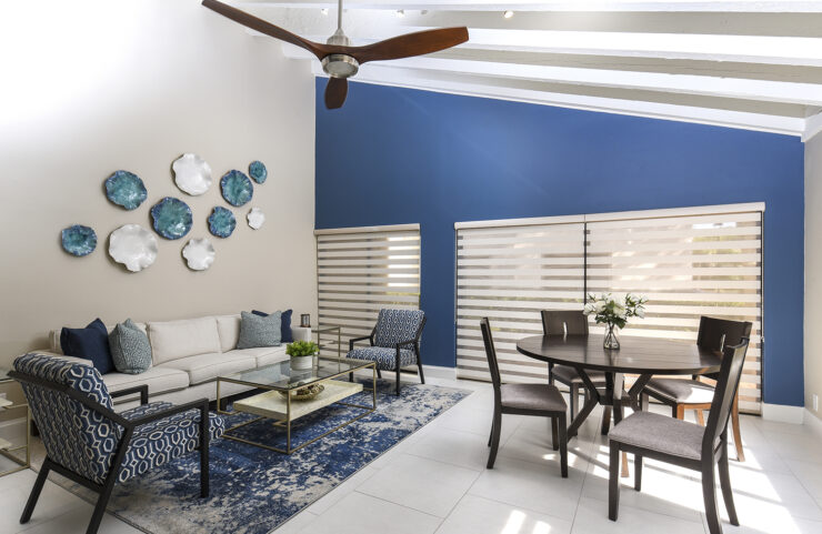 bright living and dining area with ceiling fan and tile floors