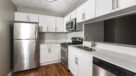 upgraded kitchen with white cabinets and stainless steel appliances