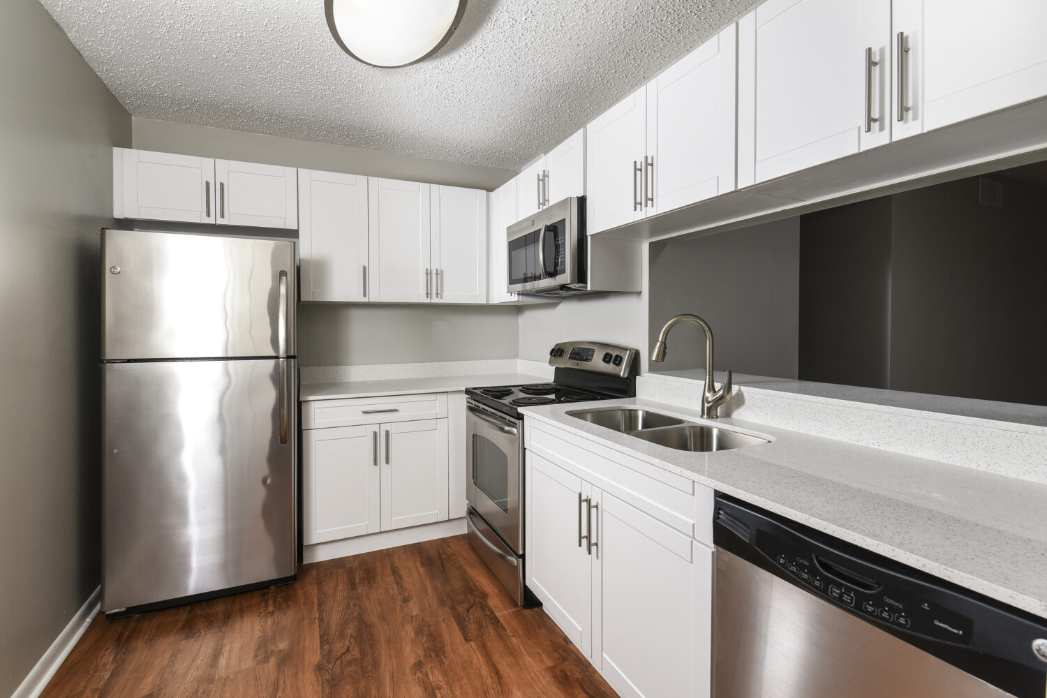 upgraded kitchen with white cabinets and stainless steel appliances