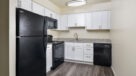 upgraded kitchen with white cabinets and black appliances