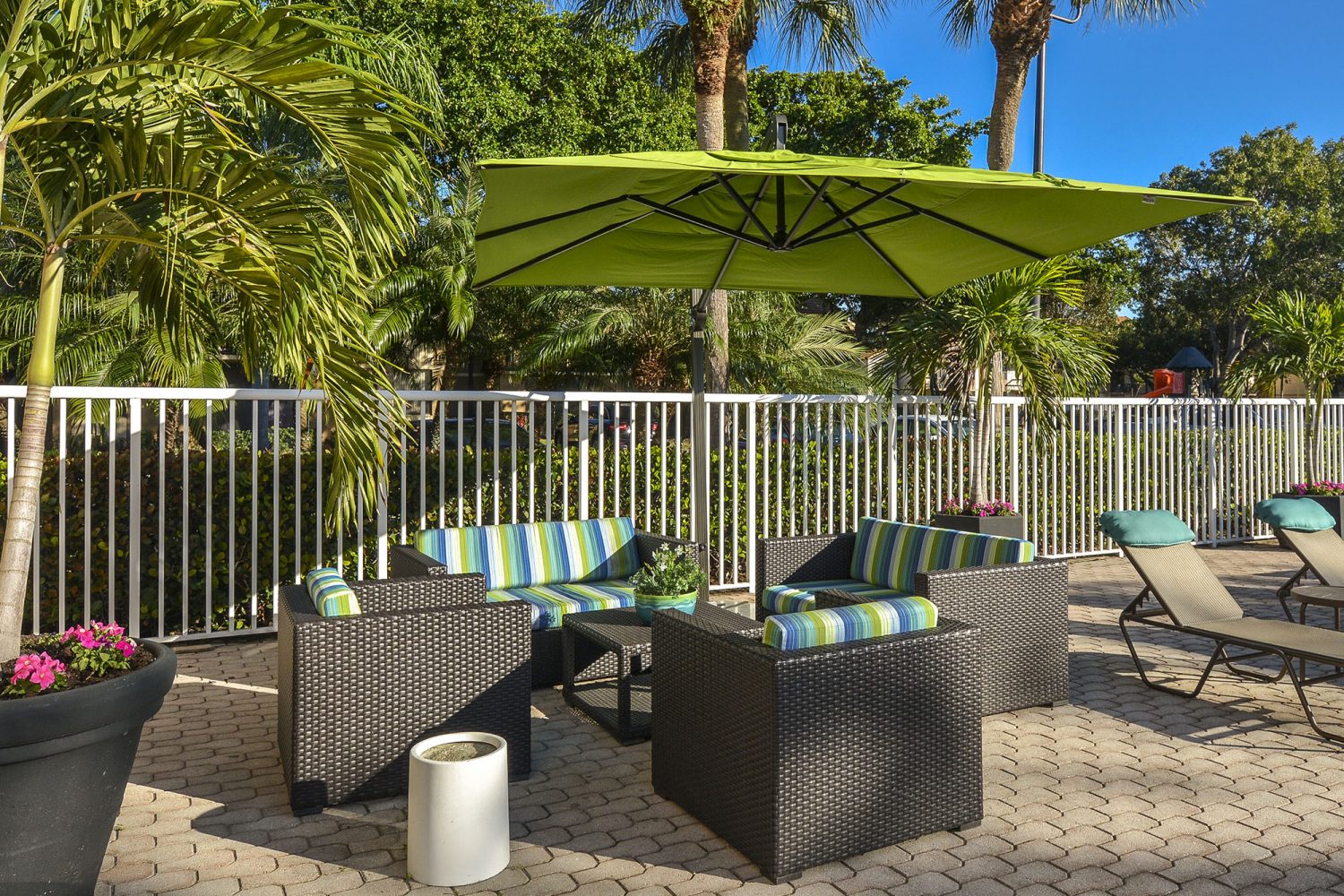comfy seating area with umbrellas by the pool 