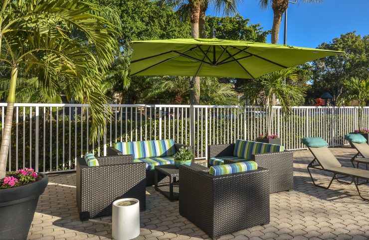 comfy seating area with umbrellas by the pool 