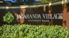 Jacaranda Village Apartments curved sign at entrance 
