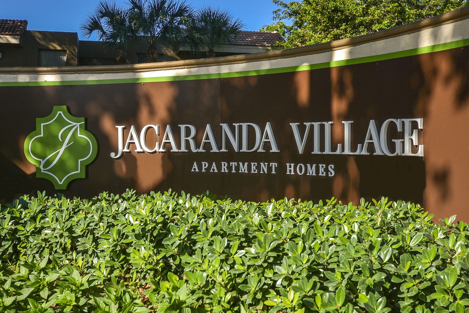 Jacaranda Village Apartments curved sign at entrance 