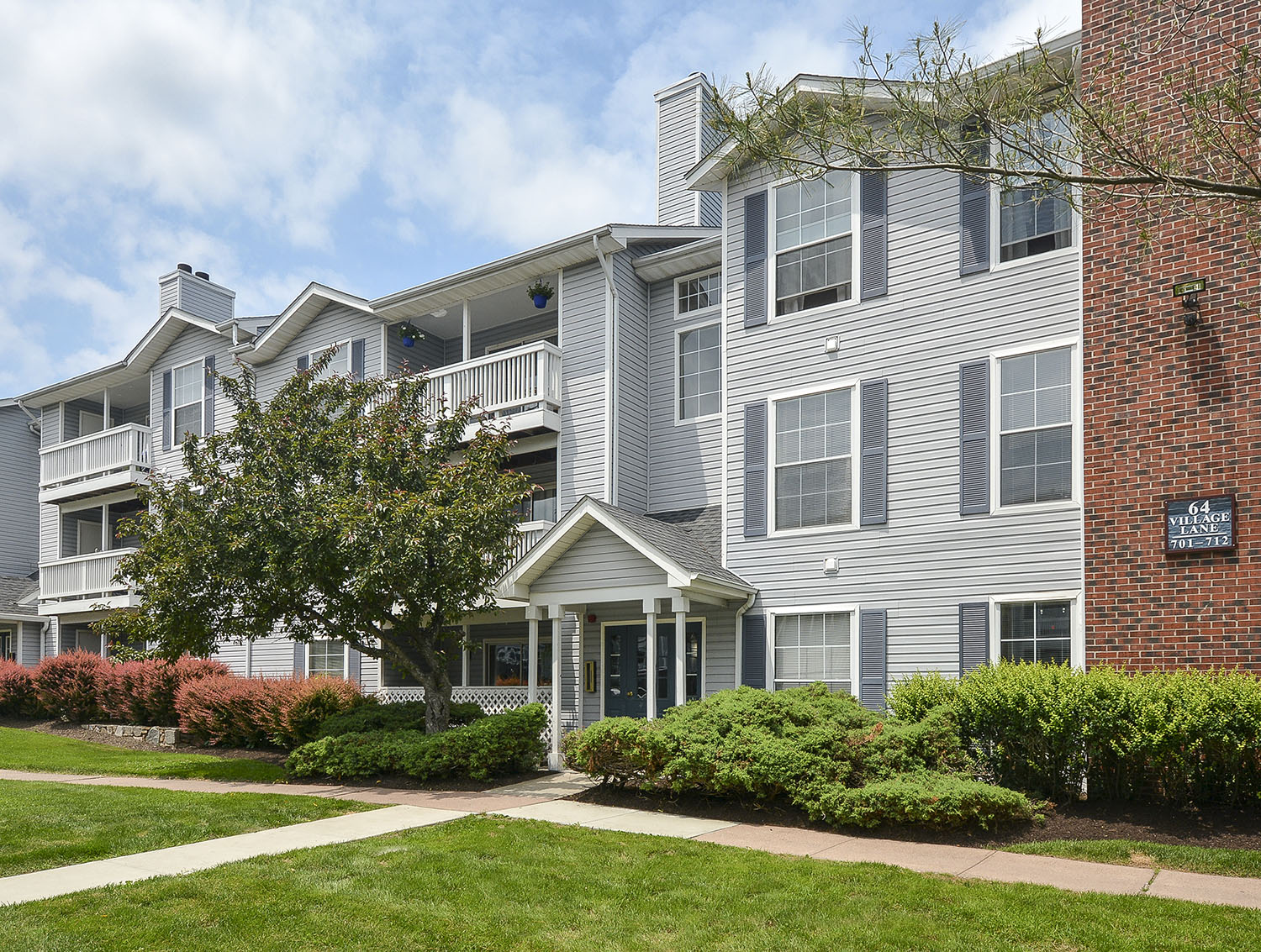 exterior photo of apartments with siding and brick facade