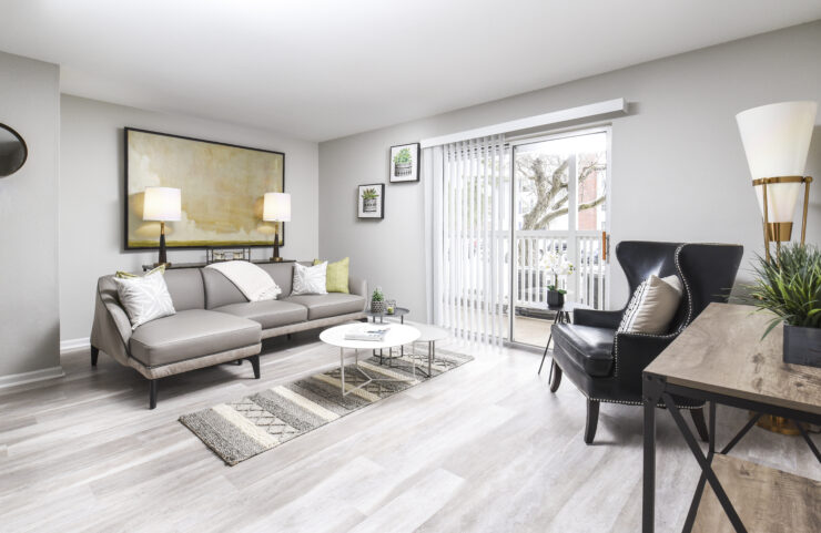 large living room with plank flooring and sliding doors to patio