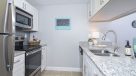 updated kitchen with white cabinets and stainless steel appliances