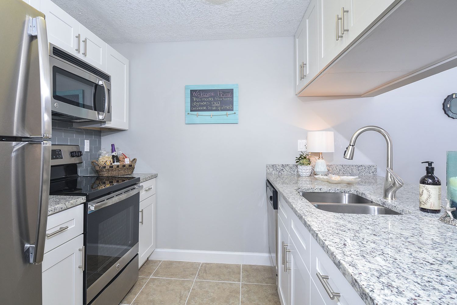 updated kitchen with white cabinets and stainless steel appliances