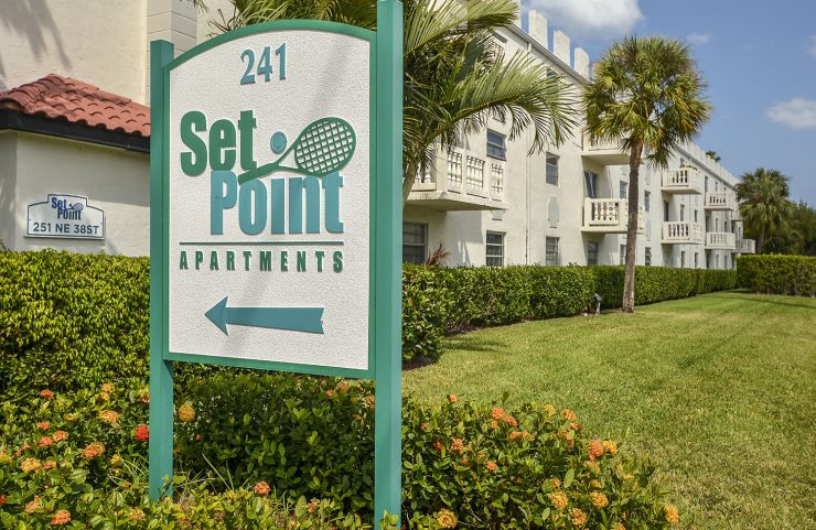set point signage with apartments in the background