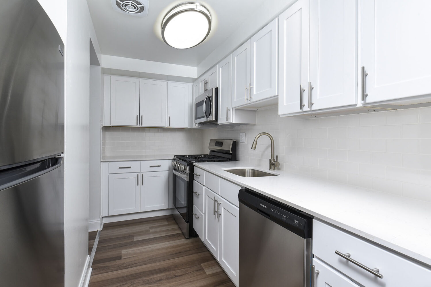 modern kitchen with white cabinets and plank flooring