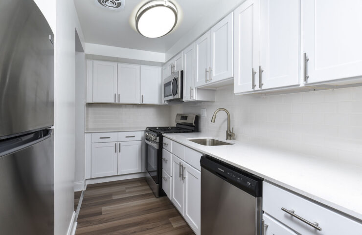 modern kitchen with white cabinets and plank flooring