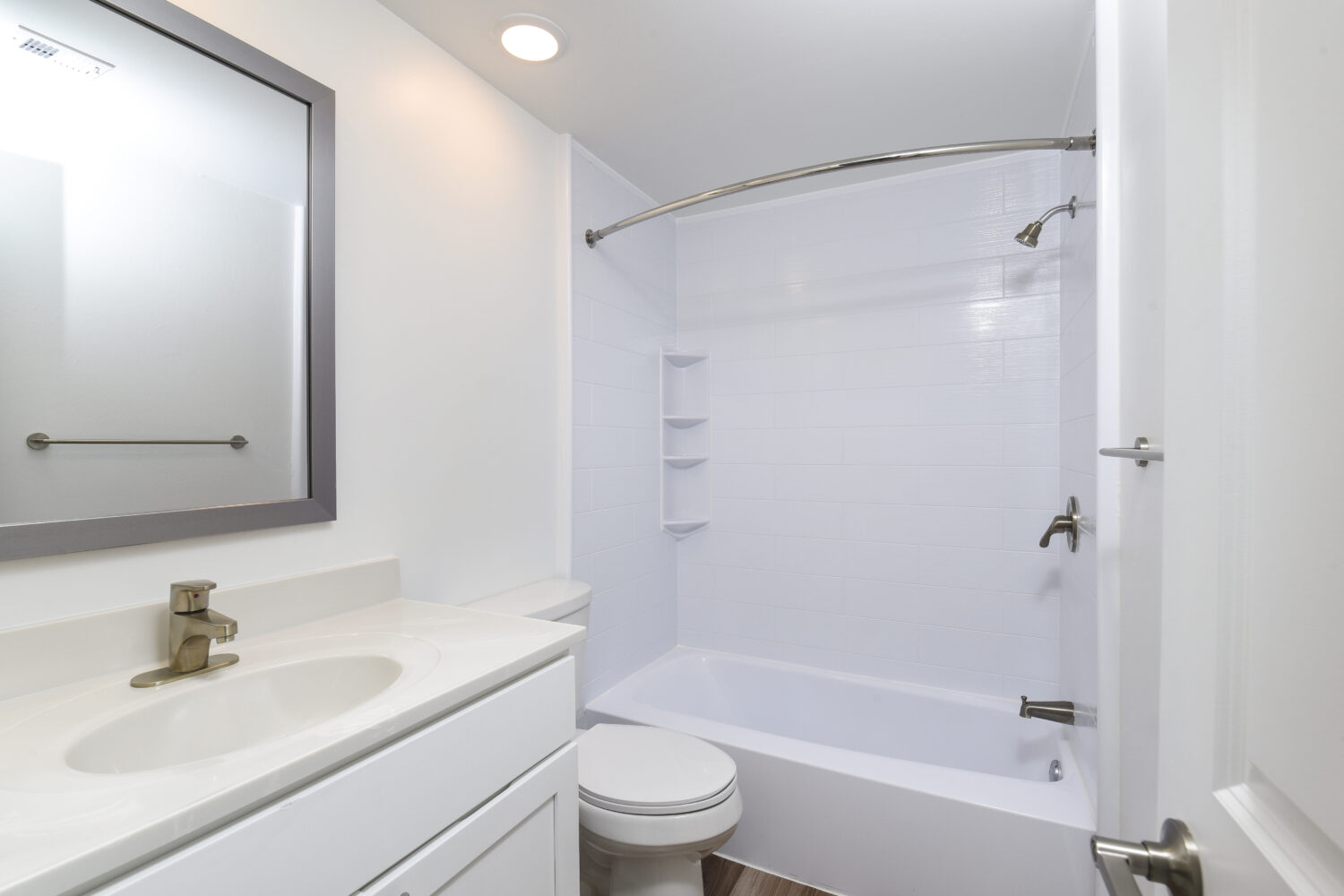 bathroom with plank flooring and tiled tub