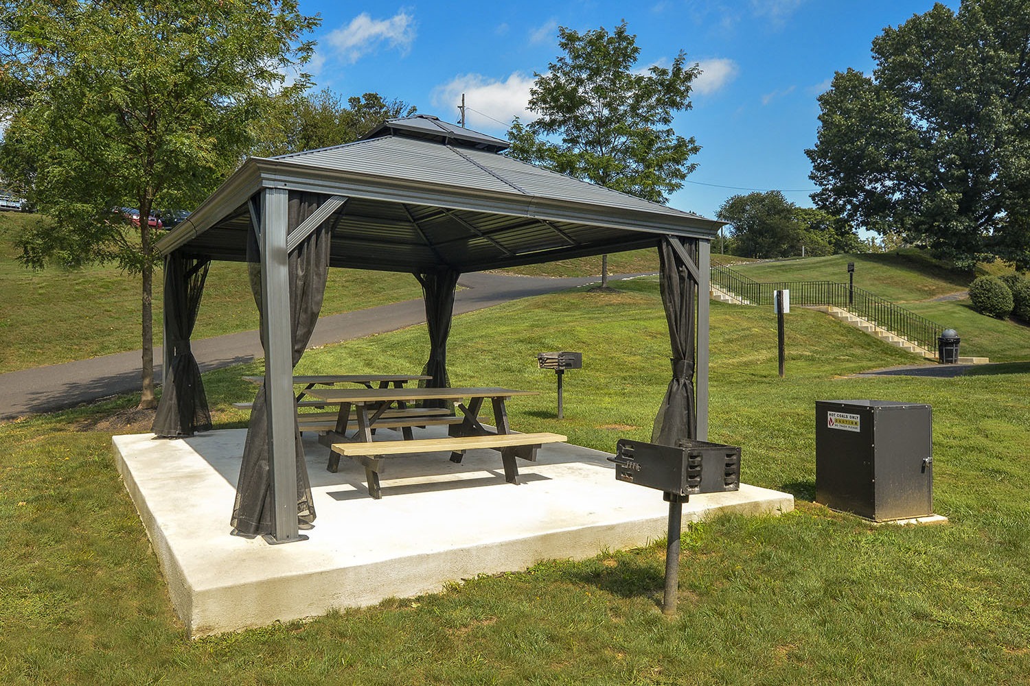 picnic bench under tent with grills 