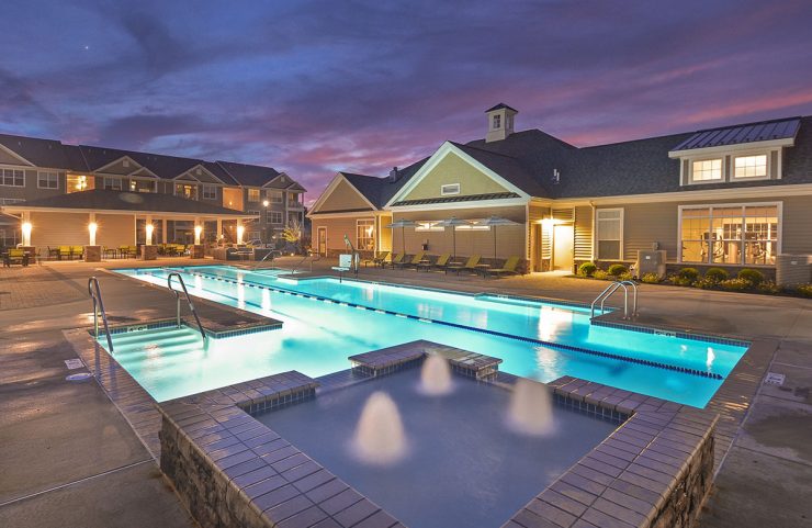 fountain and outdoor pool lit up at night 
