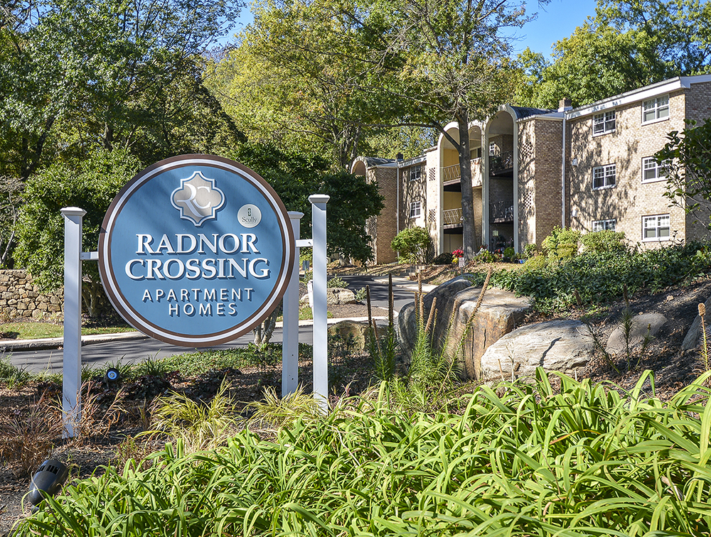 round blue radnor crossing sign at entrance of community