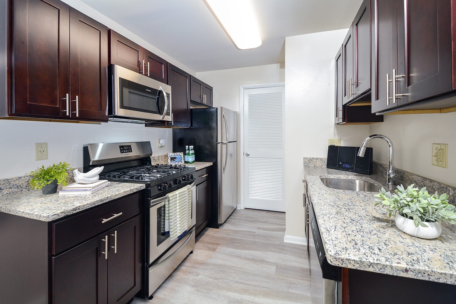 Galley style kitchen with stainless steel appliances and granite countertops