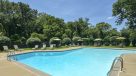 outdoor pool with lounge chairs and umbrella tables around 