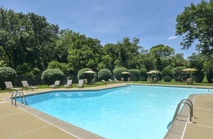 outdoor pool with lounge chairs and umbrella tables around 