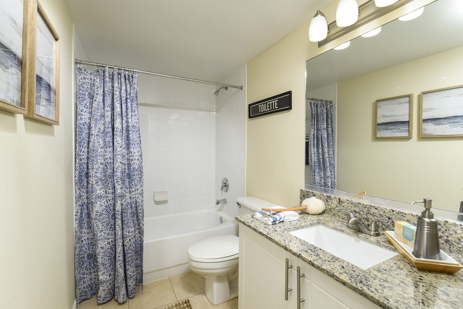 bathroom with white vanity adn tiled tub 