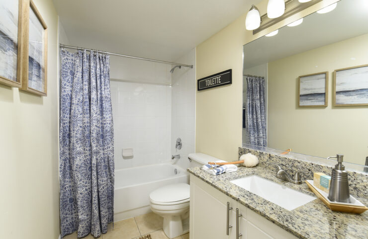 bathroom with white vanity adn tiled tub 