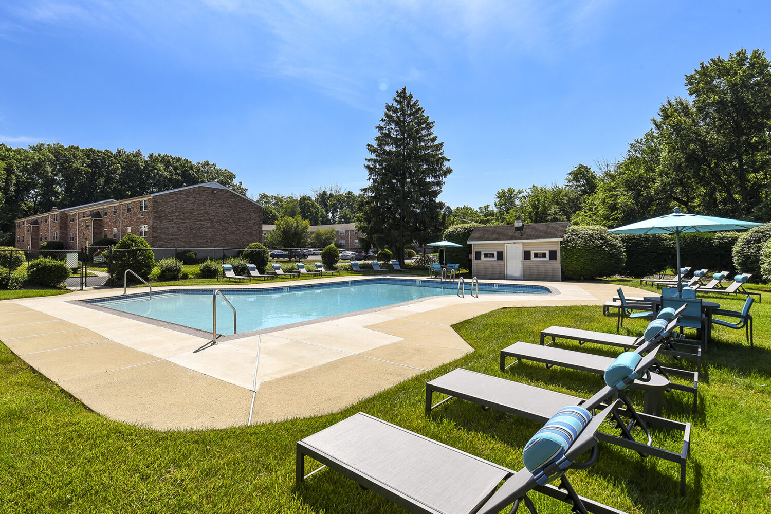 outdoor pool surrounded by lounge chairs and tables