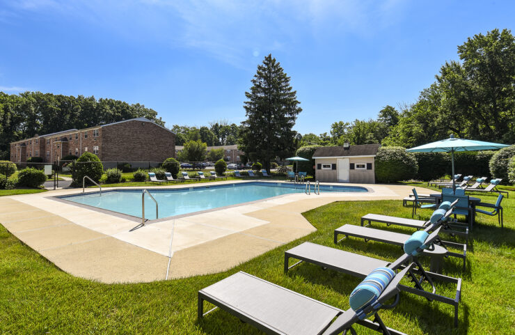 outdoor pool surrounded by lounge chairs and tables