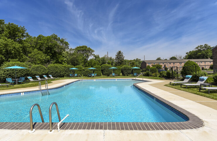 outdoor pool surrounded by lounge chairs and tables