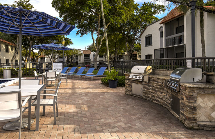 poolside grilling area with umbrella tables 