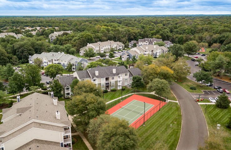 aerial view of tennis court and apartments 