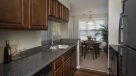 galley style kitchen with dark wood cabinets and stainless steel appliances 