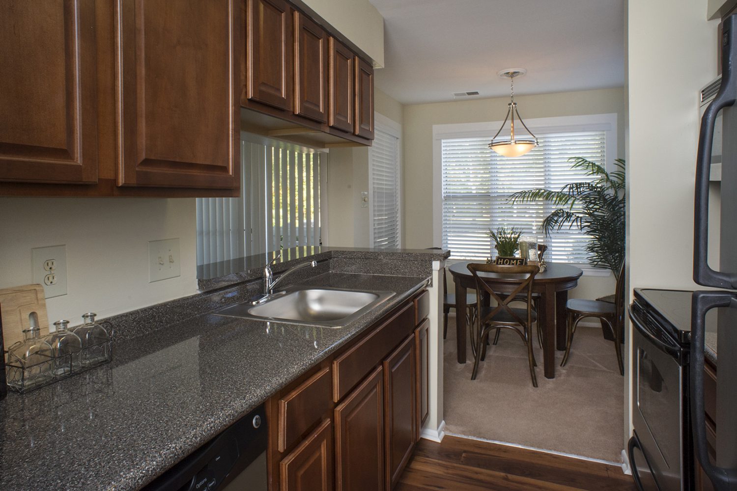 galley style kitchen with dark wood cabinets and stainless steel appliances 