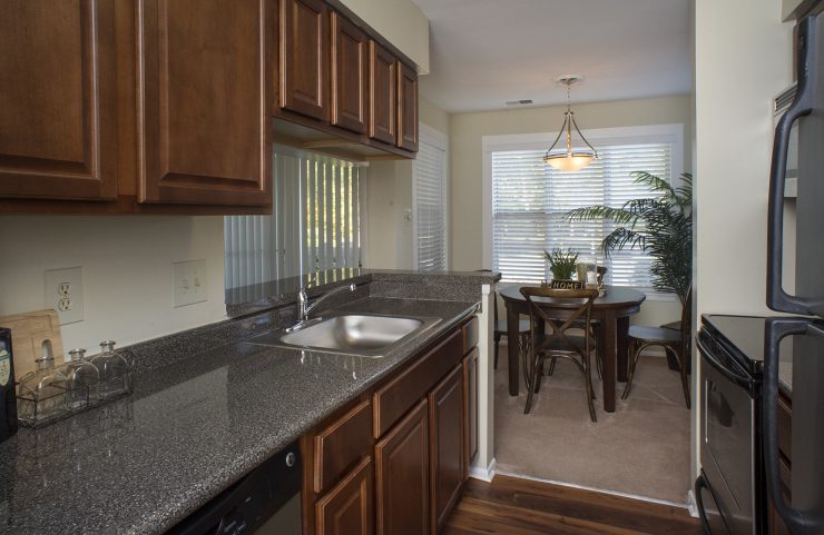 galley style kitchen with dark wood cabinets and stainless steel appliances 
