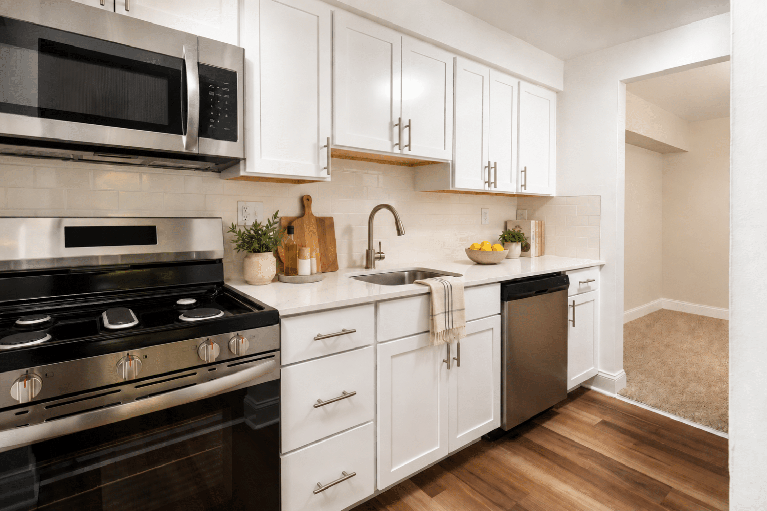 modern kitchen with white cabinets and plank flooring