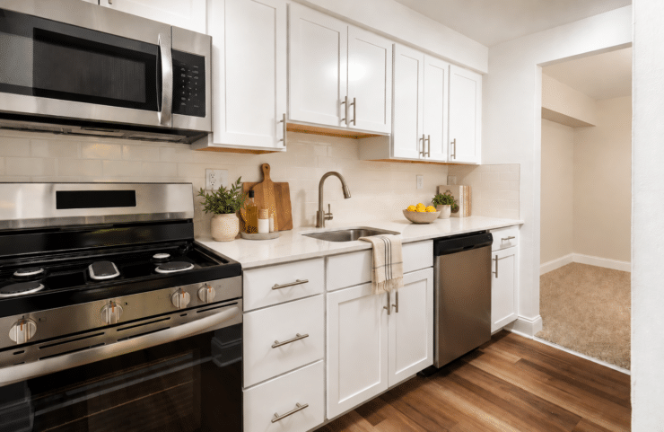 modern kitchen with white cabinets and plank flooring