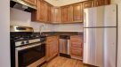 updated kitchen with medium wood cabinets and gas stove 