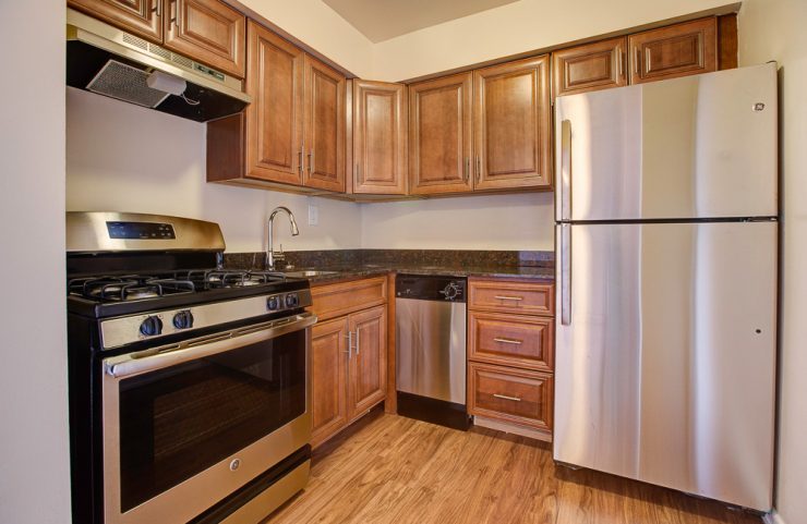 updated kitchen with medium wood cabinets and gas stove 