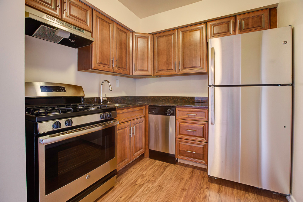 updated kitchen with medium wood cabinets and gas stove