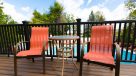 chairs and small table on the sun deck overlooking the pool 
