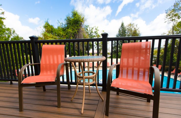 chairs and small table on the sun deck overlooking the pool 