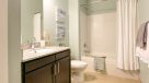 bathroom with granite countertops and tile tub