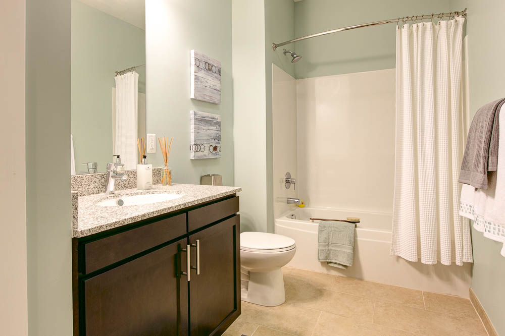 bathroom with granite countertops and tile tub