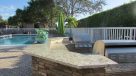 outdoor kitchen area with gas grills by the pool 