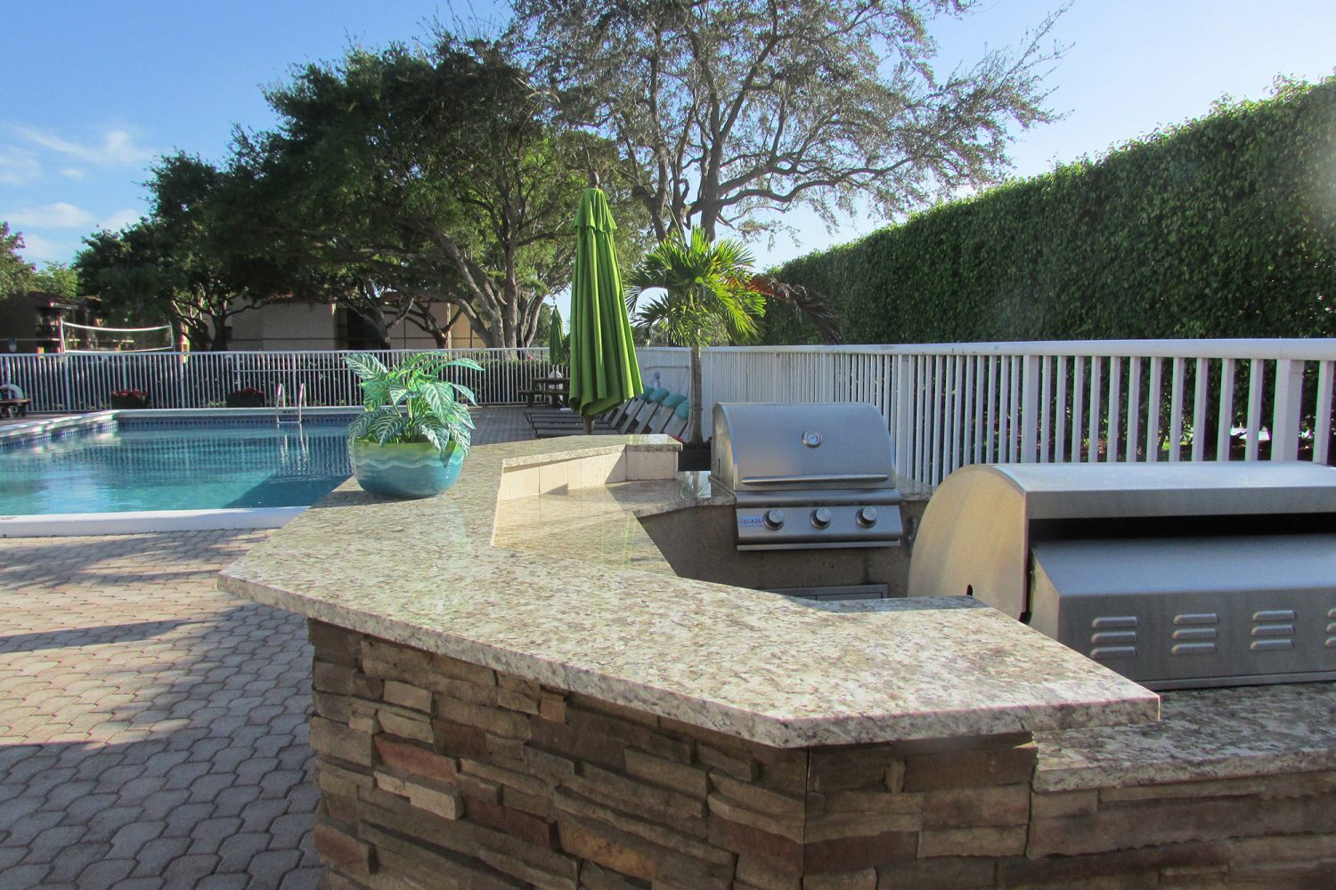 outdoor kitchen area with gas grills by the pool 