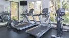 fitness center with one elliptical, two treadmills and a bike facing the window 