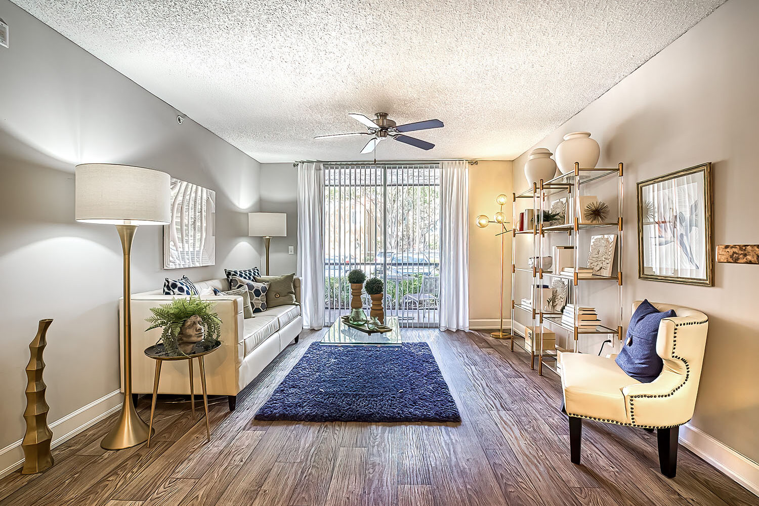 large living room with light wood flooring and sliding door to private patio