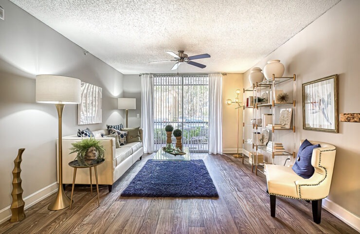 large living room with light wood flooring and sliding door to private patio